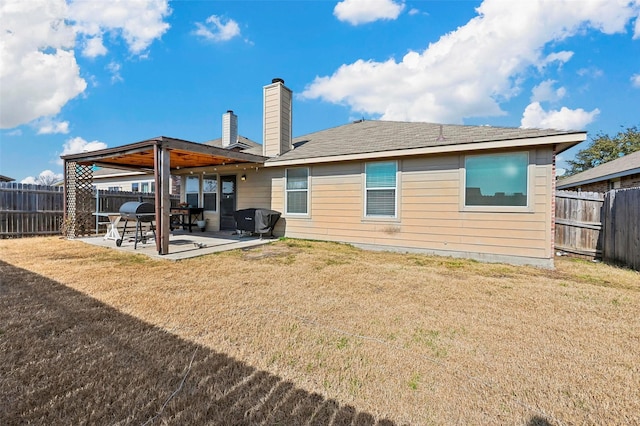 rear view of house with a patio area and a lawn