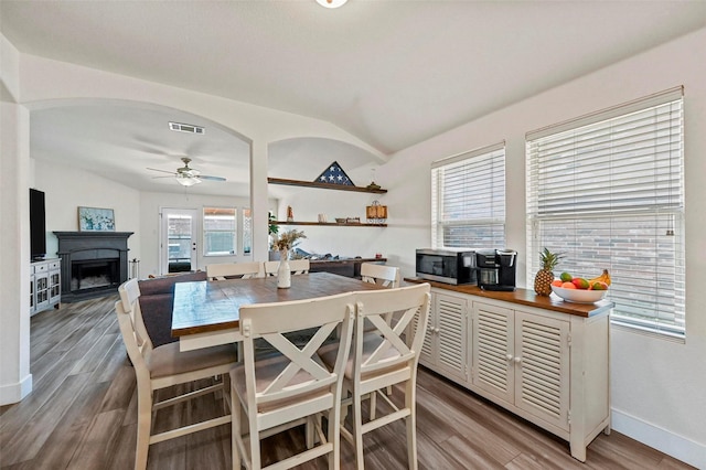 dining space featuring hardwood / wood-style flooring, ceiling fan, and lofted ceiling