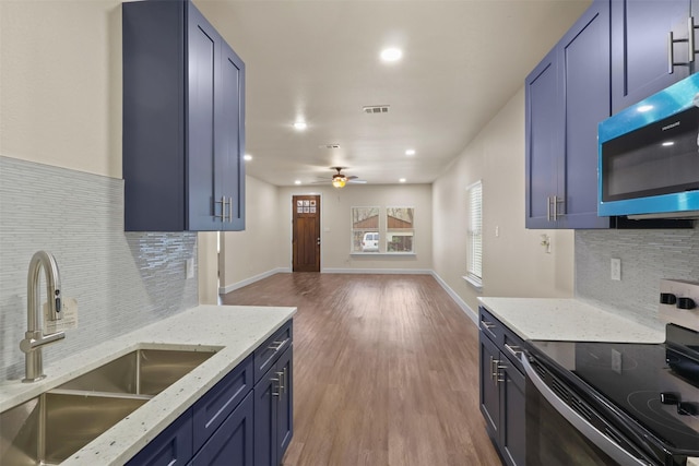 kitchen featuring blue cabinetry, stainless steel electric stove, sink, and light wood-type flooring