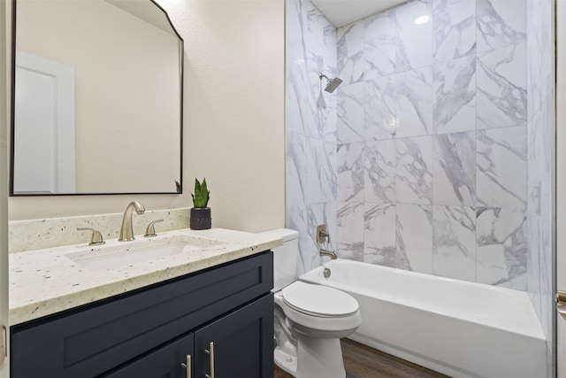 full bathroom featuring vanity, wood-type flooring, toilet, and tiled shower / bath