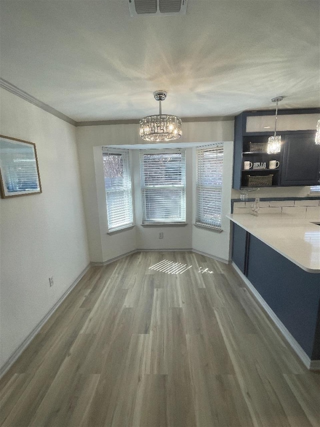 unfurnished dining area featuring plenty of natural light, dark hardwood / wood-style floors, and a notable chandelier