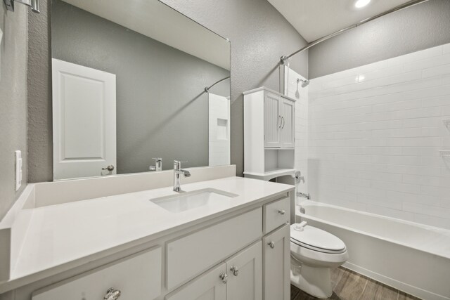 full bathroom featuring vanity, hardwood / wood-style floors, tub / shower combination, and toilet