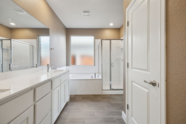 bathroom with vanity and separate shower and tub