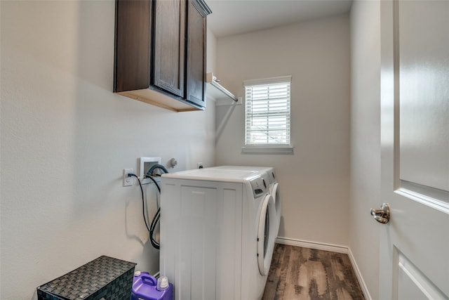 washroom featuring dark wood-type flooring, washing machine and dryer, and cabinets