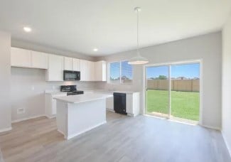 kitchen featuring pendant lighting, white cabinetry, stove, a center island, and light wood-type flooring