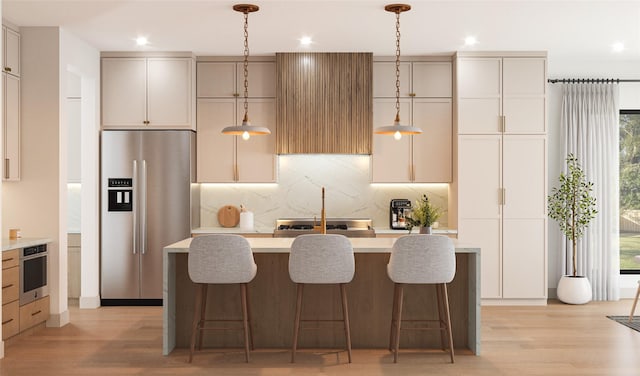 6346 Palo Pinto Ave, Dallas, TX 75214 - kitchen featuring an island with sink, light wood-style floors, stainless steel appliances, and light countertops