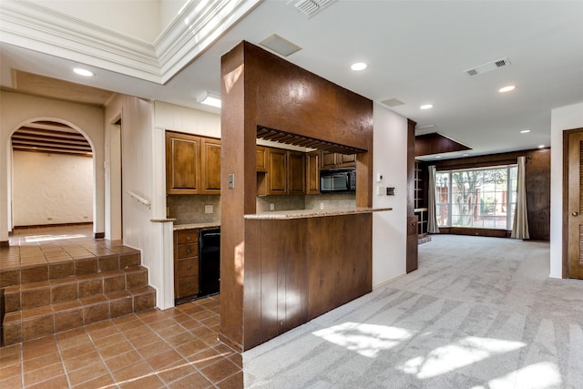 kitchen with tasteful backsplash, light colored carpet, and kitchen peninsula