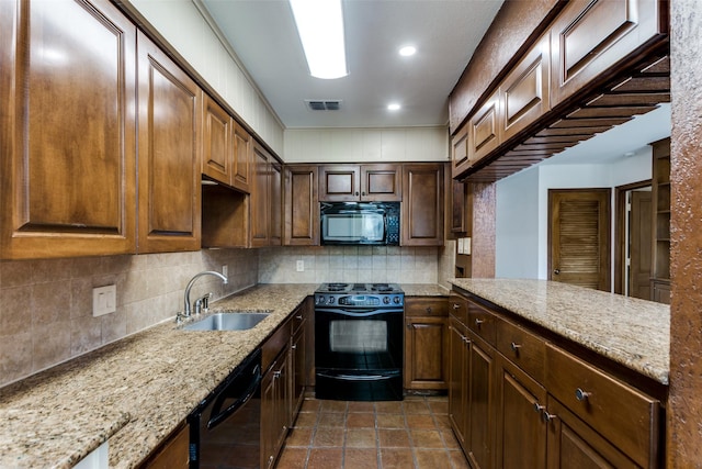 kitchen with light stone countertops, sink, backsplash, and black appliances