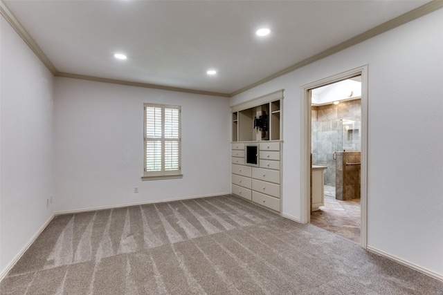 unfurnished bedroom with crown molding, connected bathroom, and light colored carpet