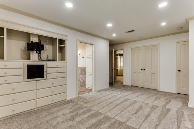 unfurnished bedroom featuring crown molding, connected bathroom, and light colored carpet