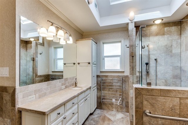 bathroom featuring tasteful backsplash, ornamental molding, vanity, and tiled shower