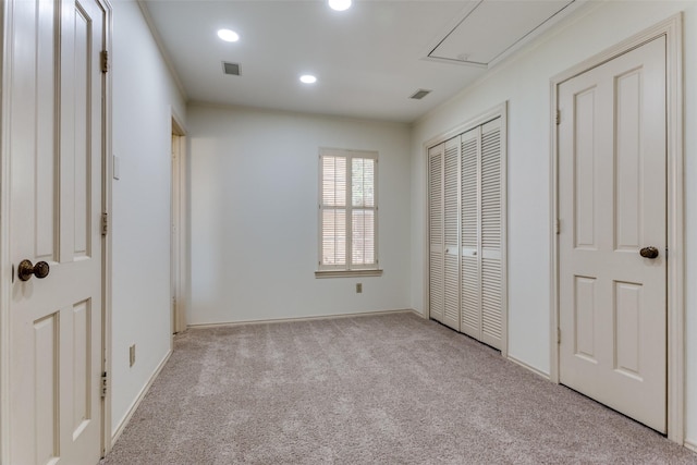 unfurnished bedroom featuring light colored carpet and a closet