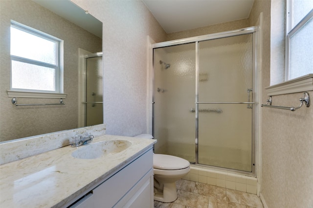 bathroom featuring vanity, a shower with shower door, tile patterned floors, and toilet