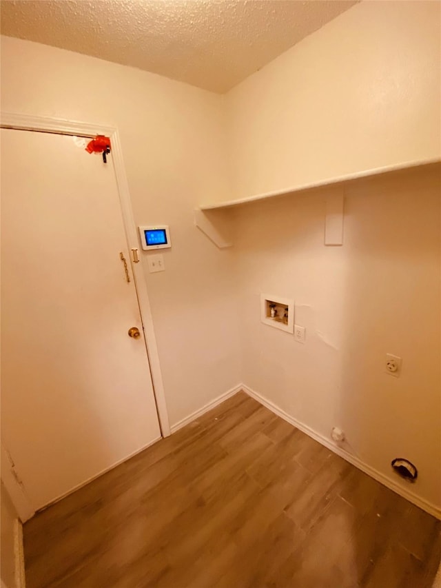 washroom featuring hookup for a washing machine, wood-type flooring, hookup for an electric dryer, and a textured ceiling