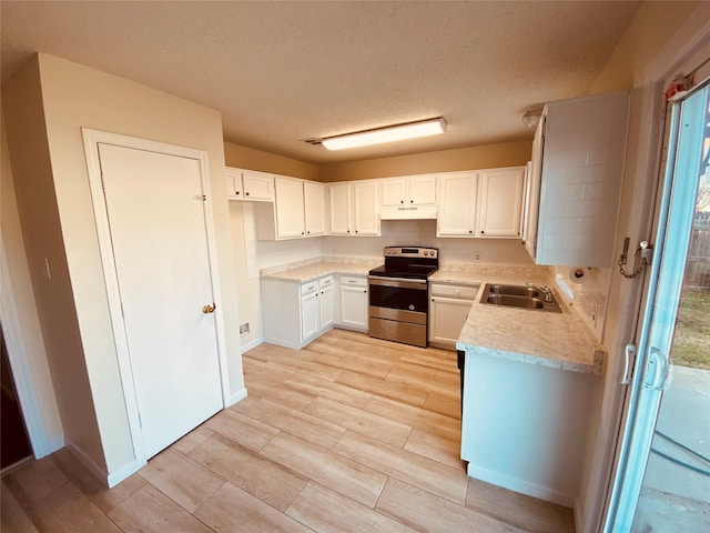 kitchen featuring white cabinetry, stainless steel range with electric stovetop, sink, and a textured ceiling