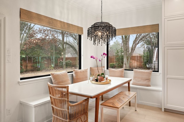 dining space featuring ornamental molding, a healthy amount of sunlight, a chandelier, and light wood-type flooring