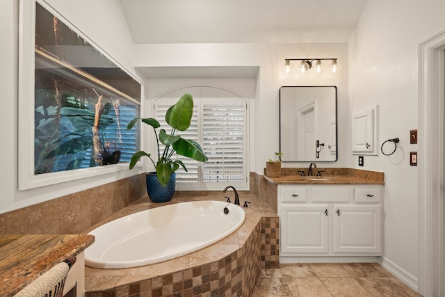 bathroom with vanity, tiled bath, and tile patterned flooring