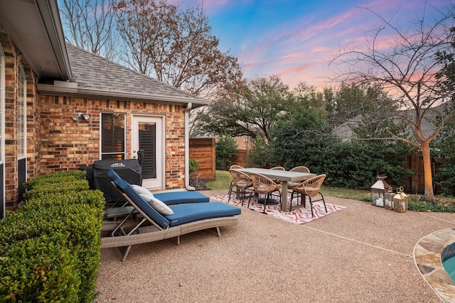 patio terrace at dusk featuring area for grilling