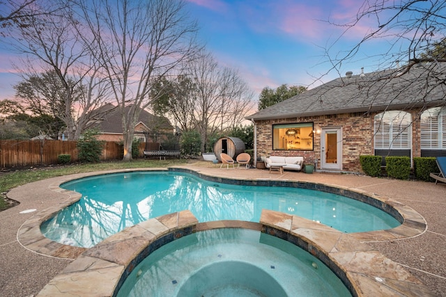 pool at dusk with an outdoor structure, a patio, and an in ground hot tub