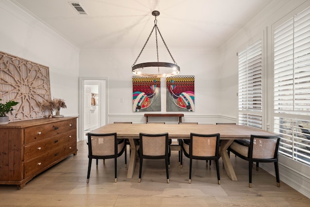 dining room featuring crown molding and light wood-type flooring