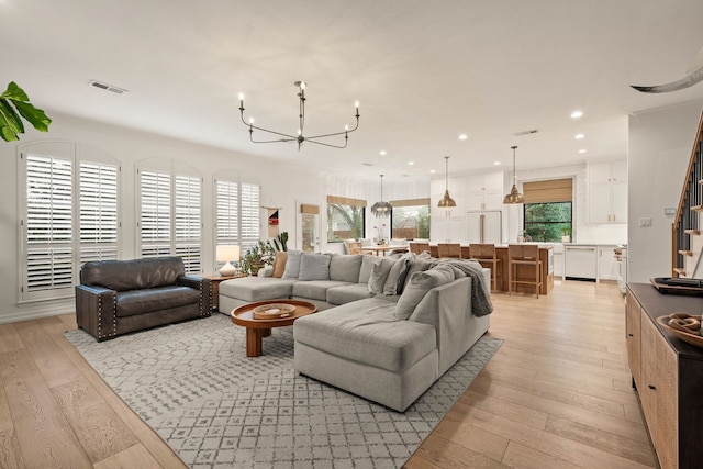 living room with a chandelier and light wood-type flooring