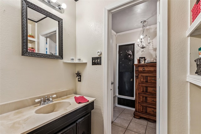 bathroom featuring a notable chandelier, tile patterned flooring, crown molding, and vanity