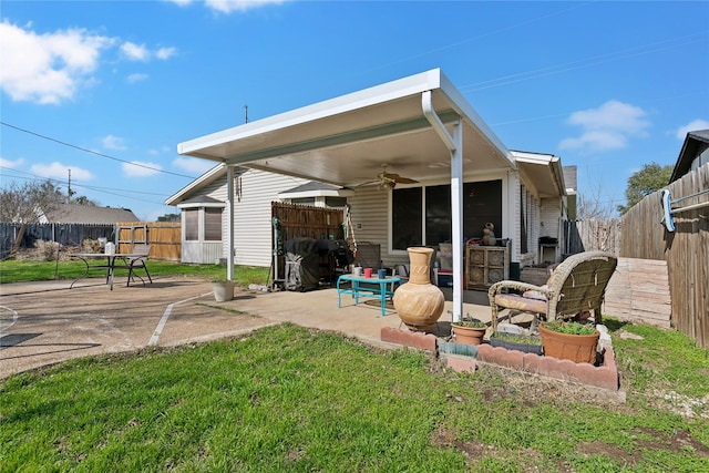 rear view of property with ceiling fan, a lawn, a patio area, and a fenced backyard