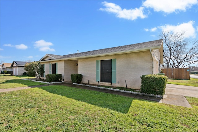 ranch-style house featuring brick siding, a front yard, and fence