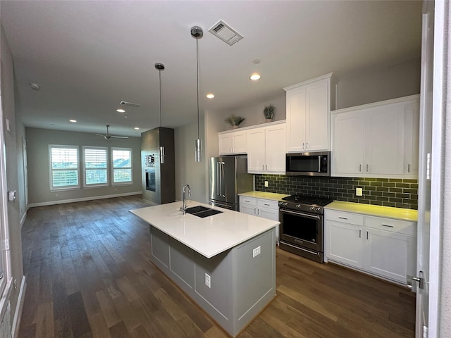 kitchen featuring sink, a kitchen island with sink, backsplash, high quality appliances, and white cabinets