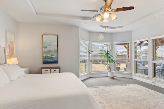 bedroom featuring a tray ceiling, ceiling fan, and carpet