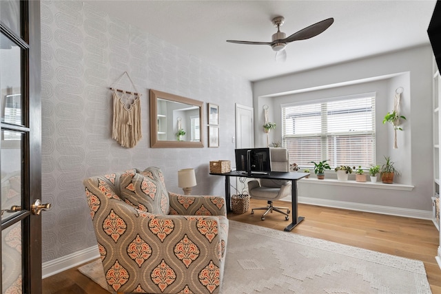 interior space featuring wallpapered walls, ceiling fan, baseboards, and wood finished floors