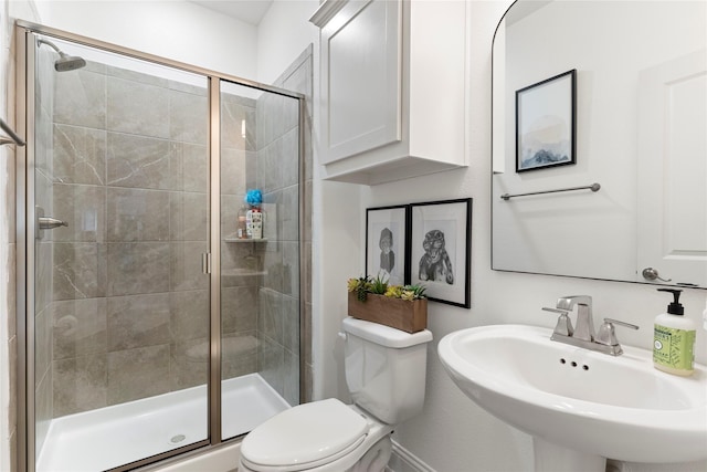 full bath featuring a sink, a shower stall, and toilet