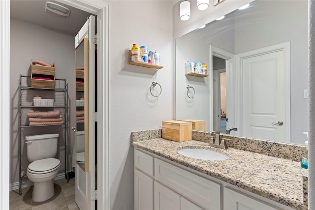 bathroom featuring vanity, tile patterned floors, and toilet