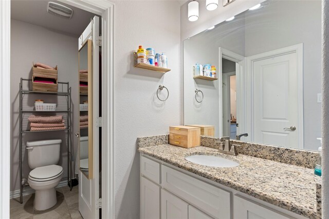 bathroom with toilet, visible vents, tile patterned flooring, and vanity