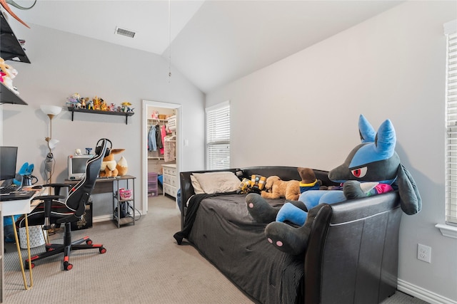 bedroom featuring visible vents, light colored carpet, vaulted ceiling, a walk in closet, and a closet