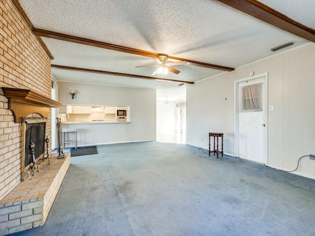 unfurnished living room with a brick fireplace, a textured ceiling, ceiling fan, brick wall, and carpet