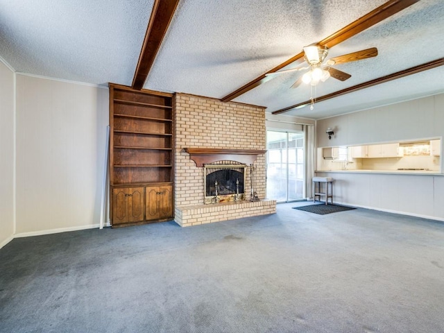 unfurnished living room featuring a brick fireplace, a textured ceiling, beamed ceiling, and carpet flooring