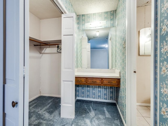 bathroom featuring vanity, tile patterned flooring, and a textured ceiling