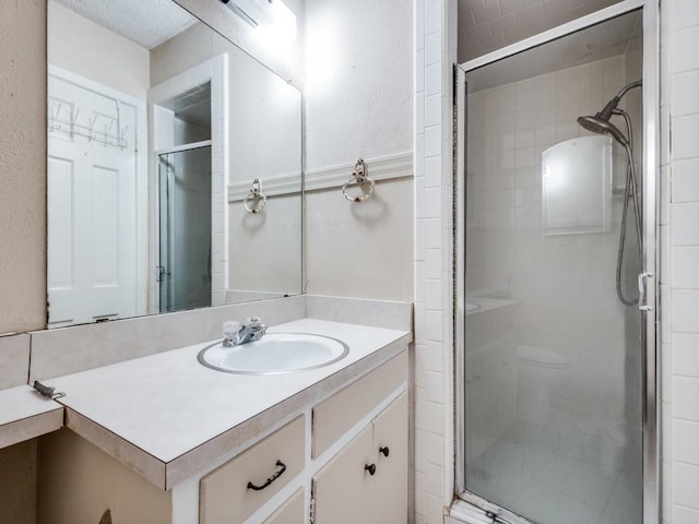 bathroom featuring walk in shower and vanity