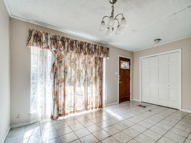 entryway featuring a chandelier, a textured ceiling, and light tile patterned floors