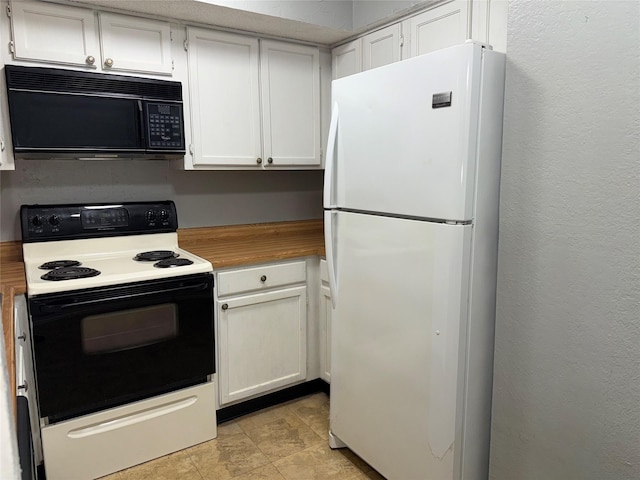 kitchen featuring electric stove, white cabinets, and white fridge