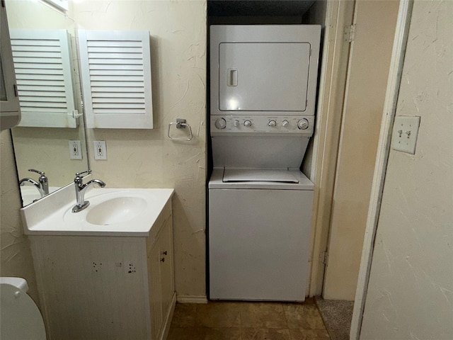 bathroom with stacked washer and dryer, vanity, and toilet