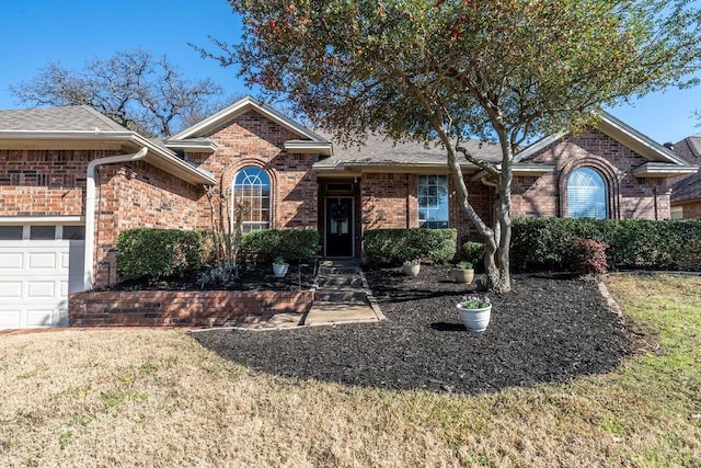 ranch-style house featuring a front lawn, brick siding, and an attached garage