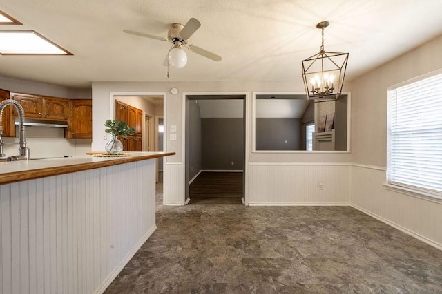 kitchen featuring ceiling fan with notable chandelier and decorative light fixtures