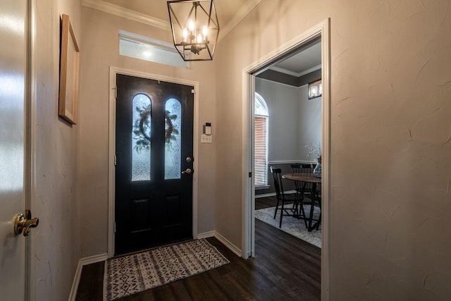 foyer featuring crown molding, dark hardwood / wood-style floors, and an inviting chandelier