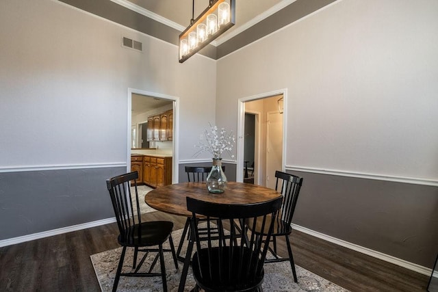 dining room featuring dark wood-type flooring and crown molding