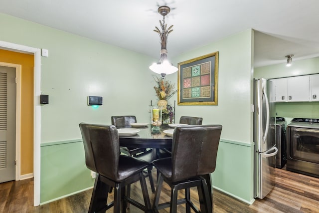 dining space featuring separate washer and dryer and dark hardwood / wood-style flooring