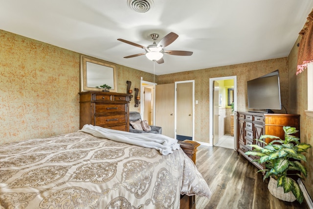 bedroom with wood-type flooring, ceiling fan, and ensuite bathroom