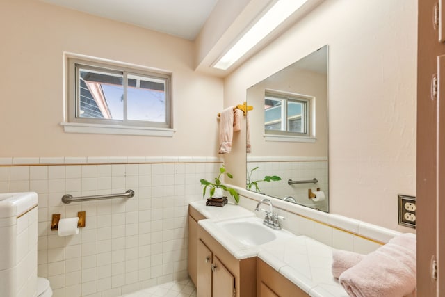 bathroom with vanity, toilet, and tile walls