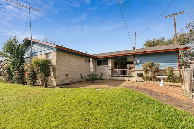 back of property featuring a yard and a patio area